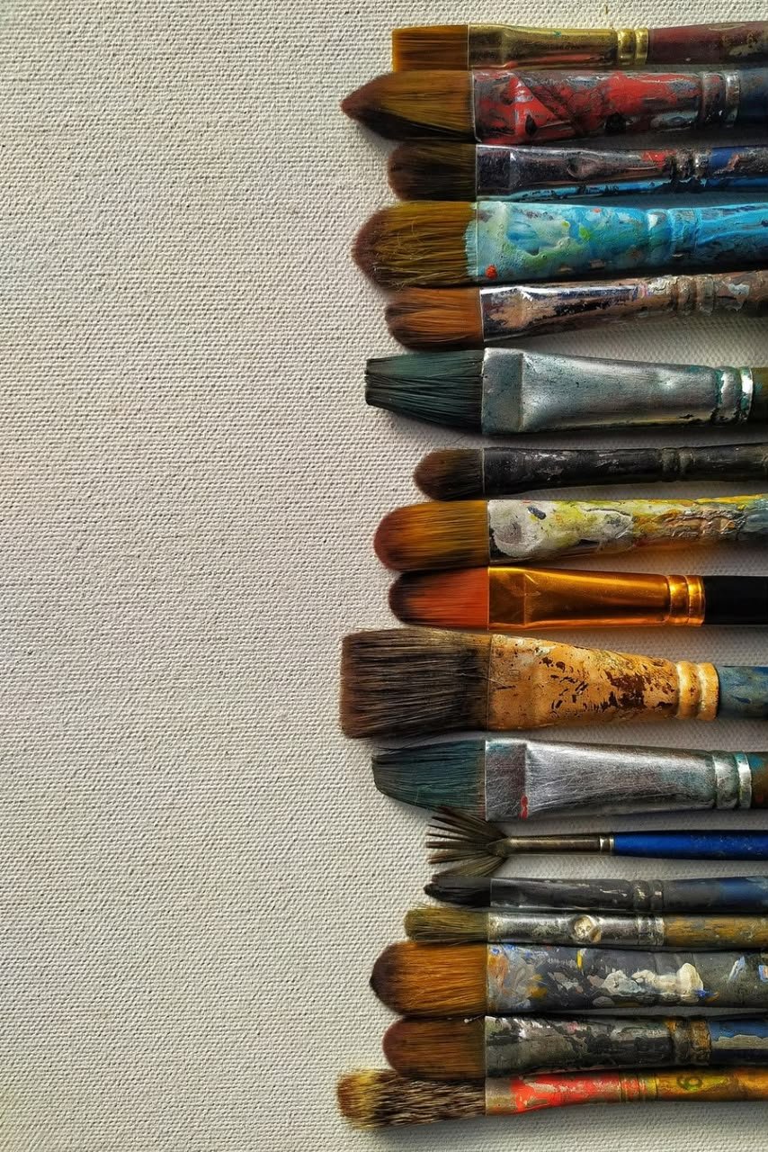 Paintbrushes resting on a well-used artist's palette
